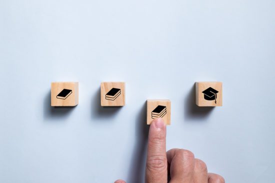 Top view wooden blocks set route from book icon to graduate icon